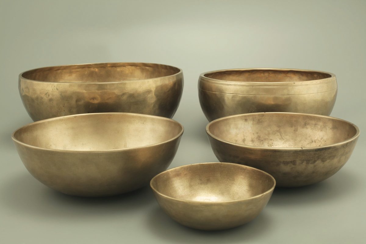 Brass singing bowls arranged on a table