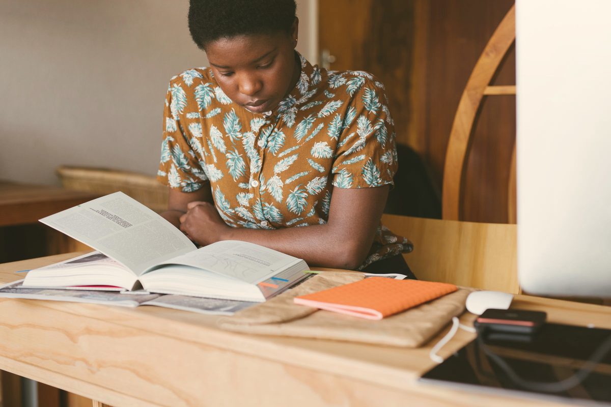 Student reading and taking notes at a desk