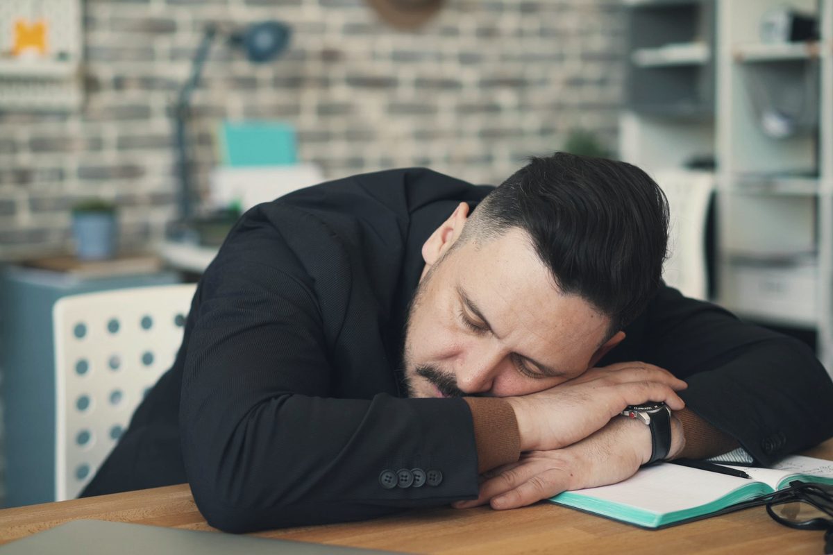 Tired man asleep on his office desk