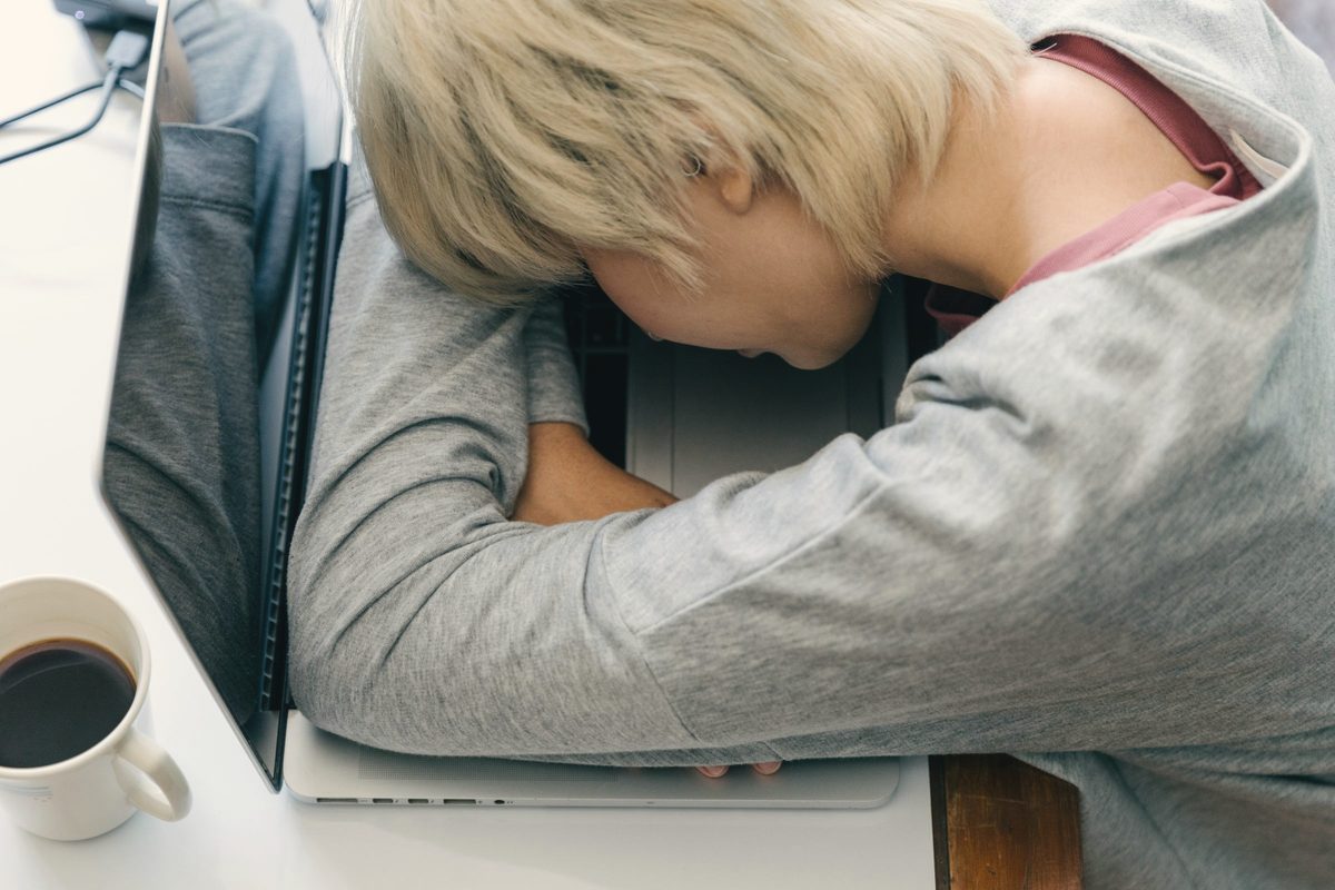 Woman asleep with her head on her laptop