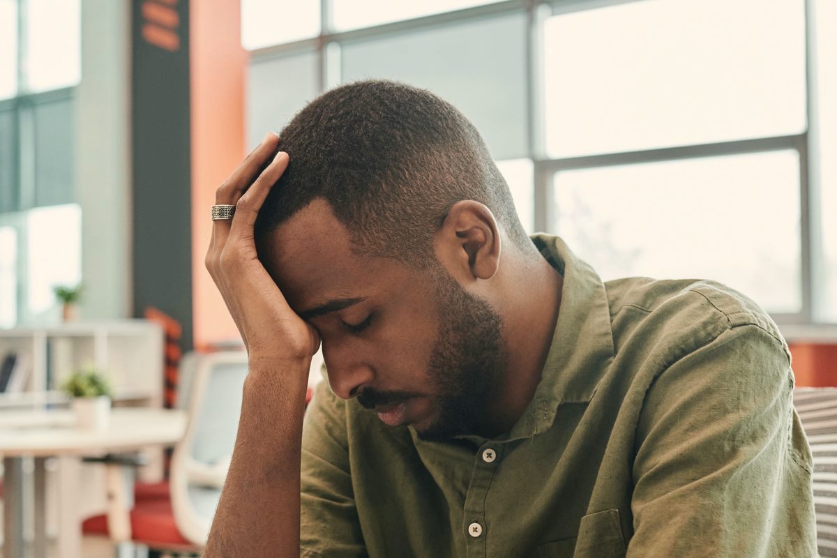 Tired man holding his head at the office