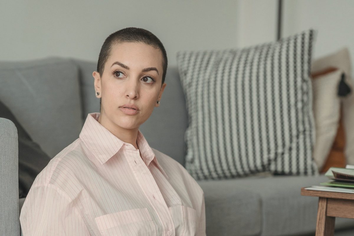 Pensive woman sitting on the floor with her laptop