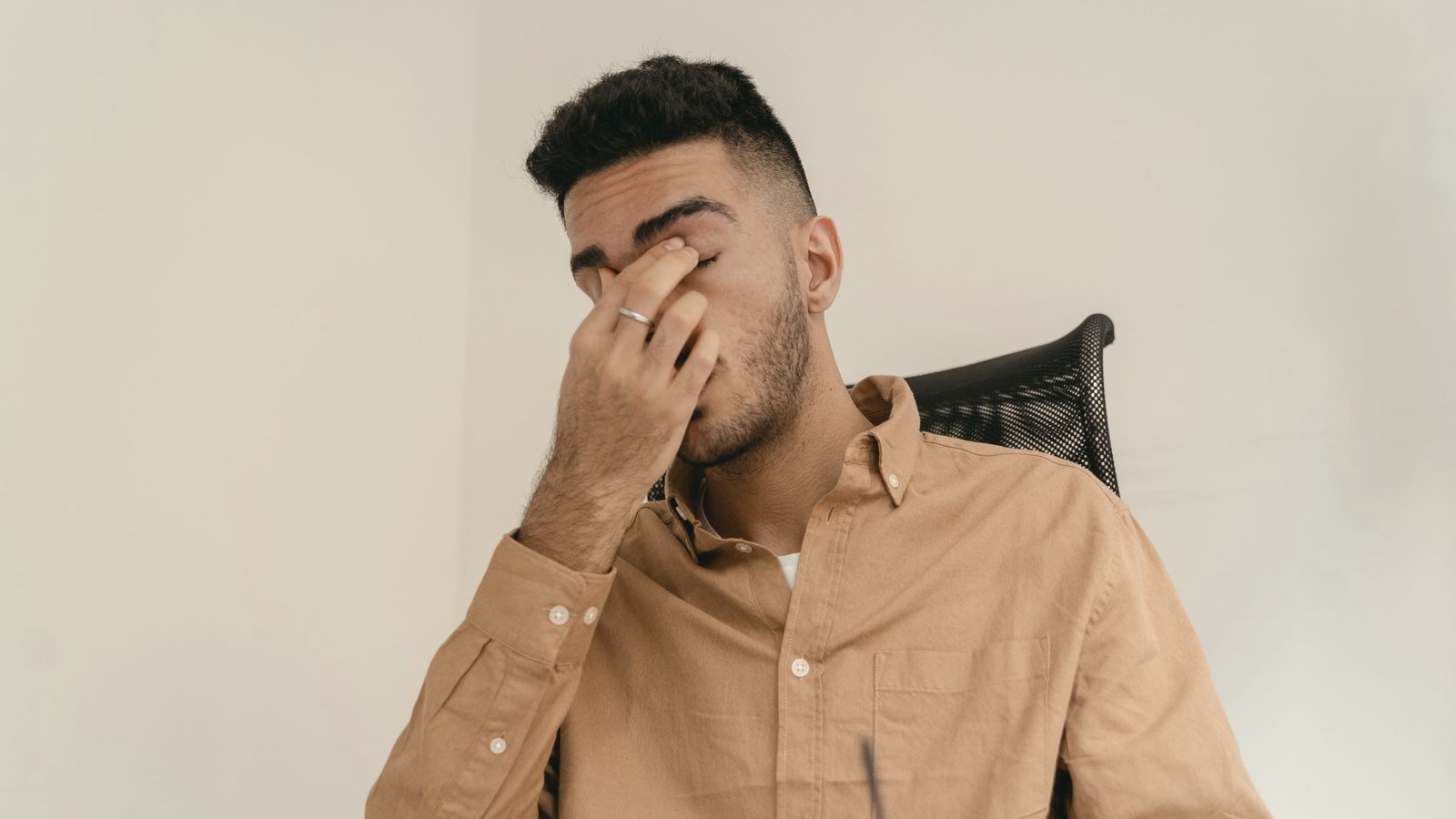 Tired man rubbing his eyes