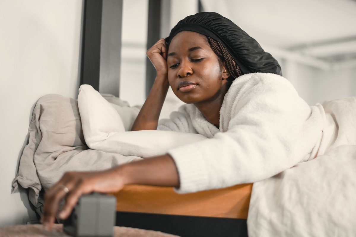 Woman reaching to switch off her alarm clock