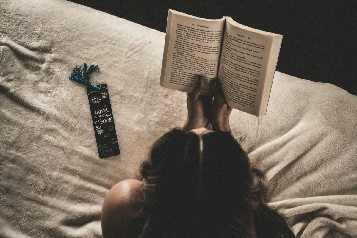 Woman reading book on bed