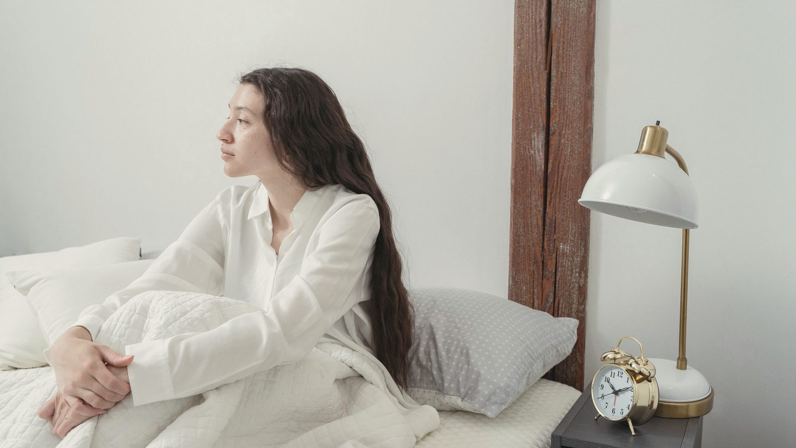 Woman sitting calmly on her bed in the morning