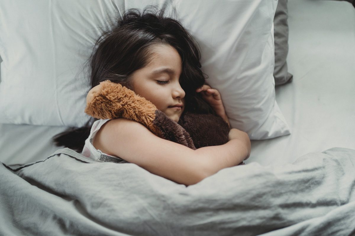 Girl sleeping with her teddy bear