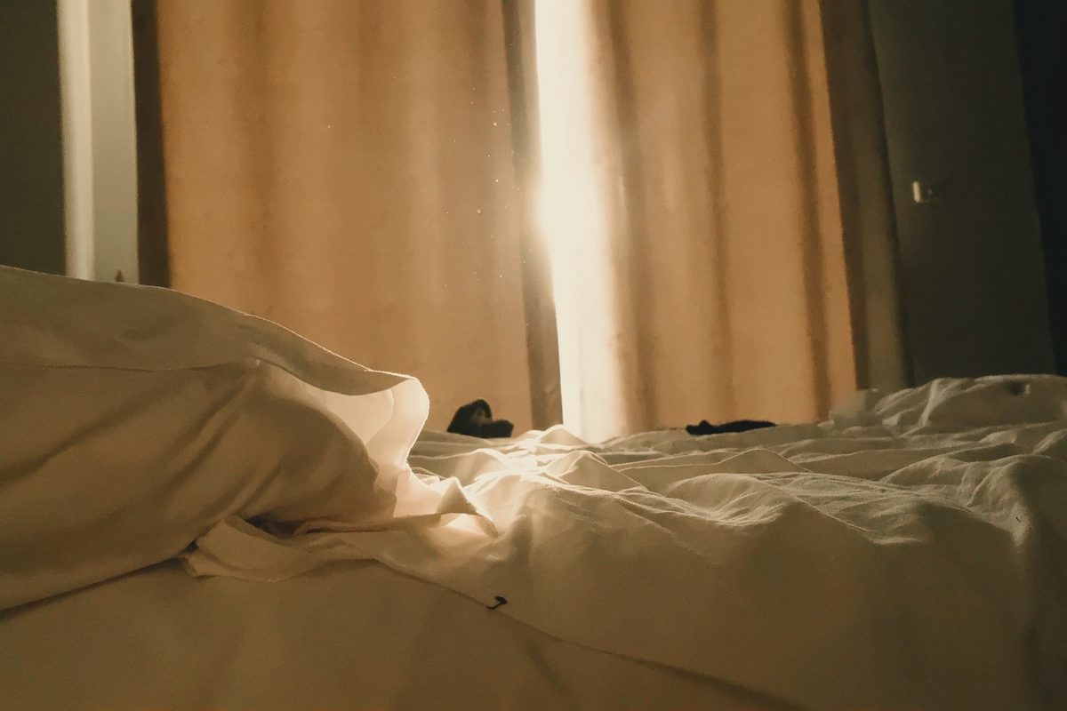Sunlit bedroom with soft morning light on the bed