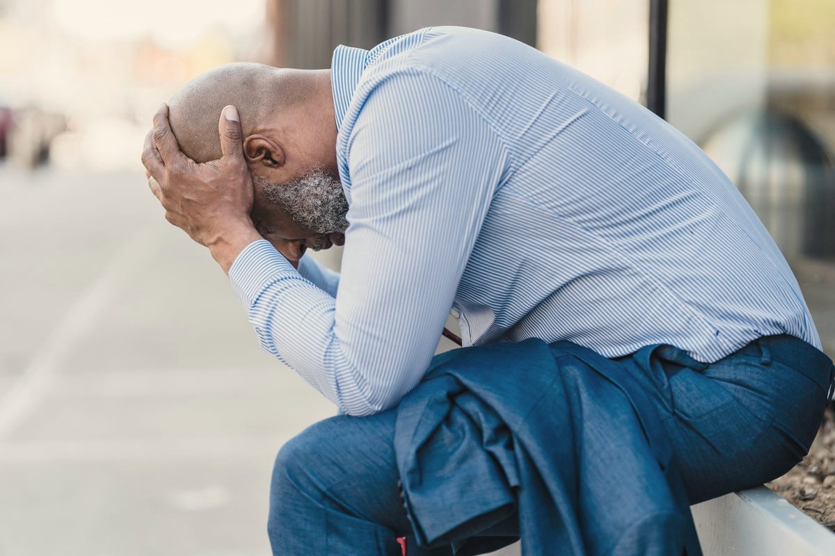 Stressed man sitting with his head in his hands