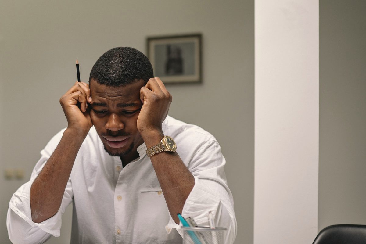 Stressed man with his head in his hands at work