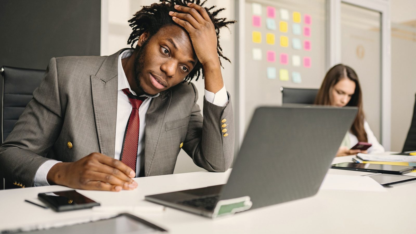 Stressed man with his hand on his head at his laptop