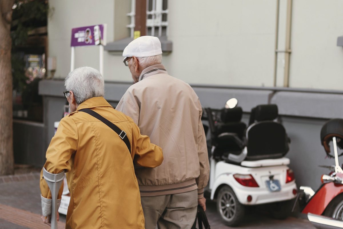 Older couple walking together down the street