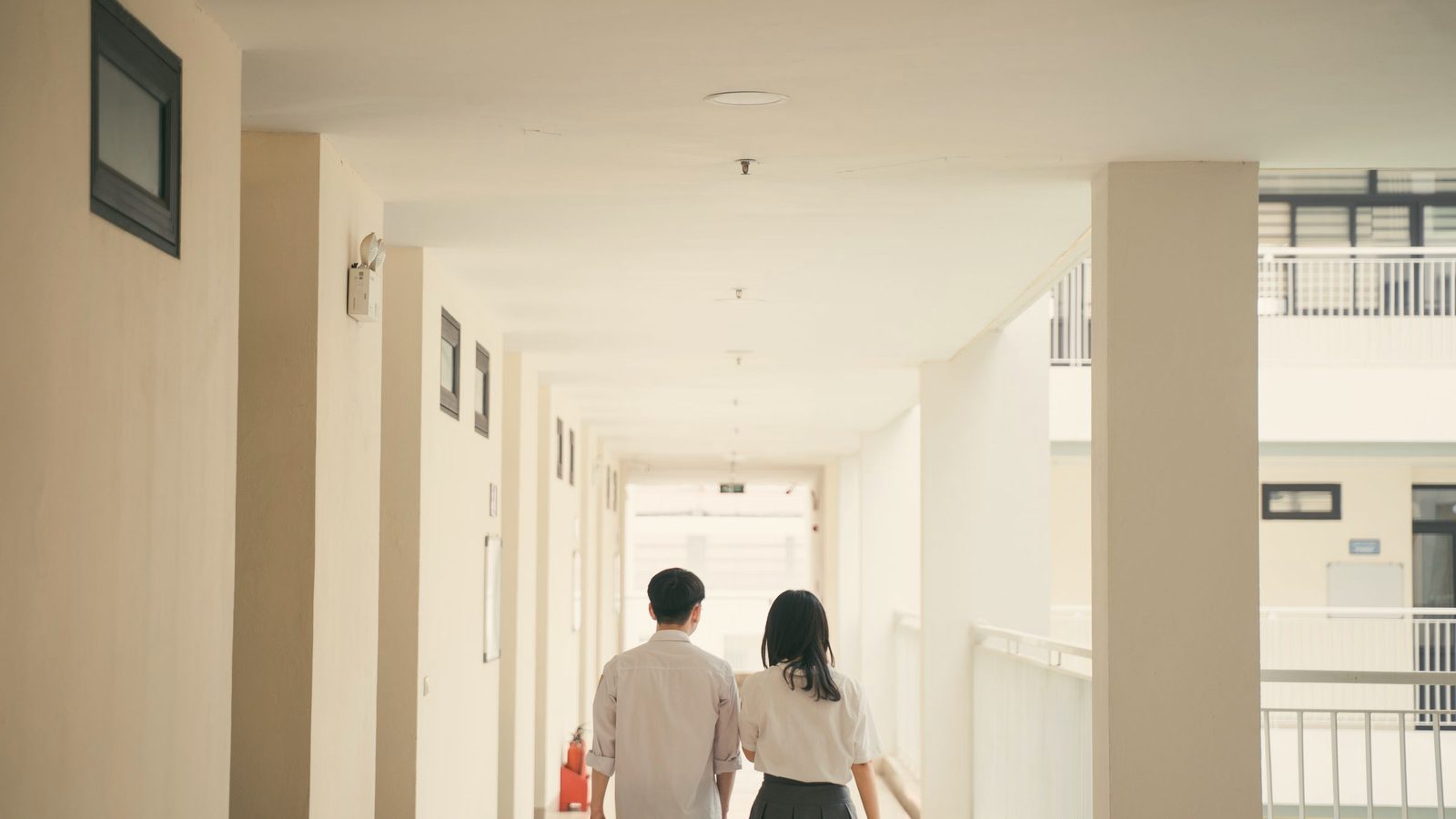 Couple walking together down a bright hallway