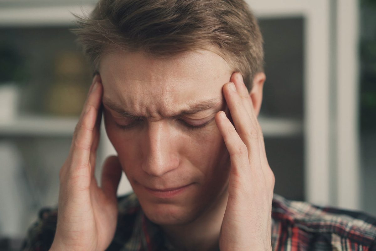 Man rubbing his temples with a worried look