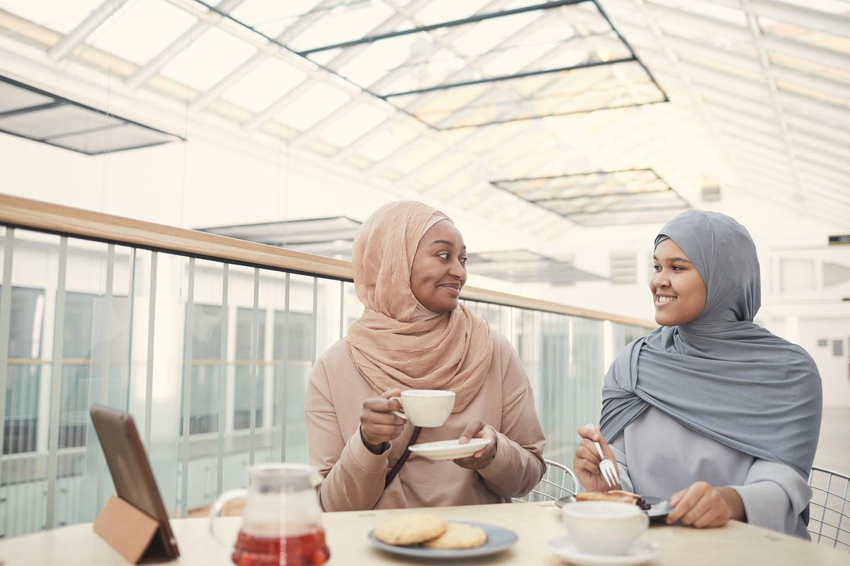 Women wearing hijab eating breakfast at the table