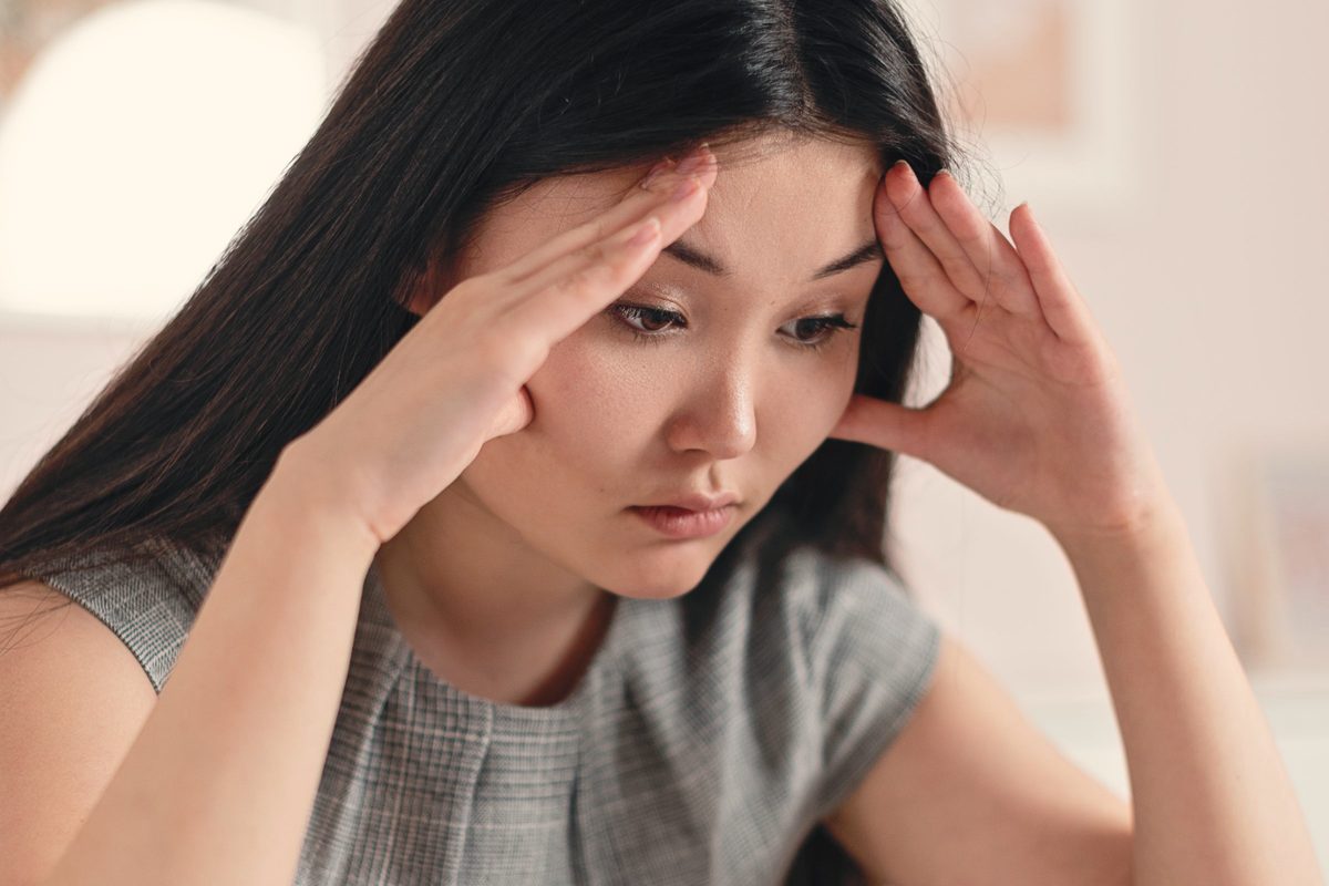 Stressed woman with her hands on her head