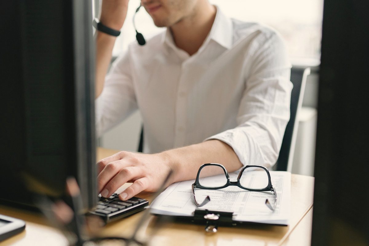 A tired man sitting at his desk rubbing his eyes