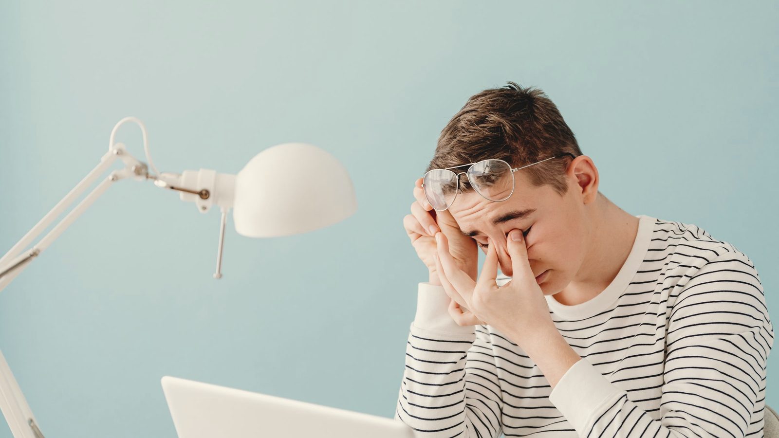 Tired man rubbing his eyes at his laptop