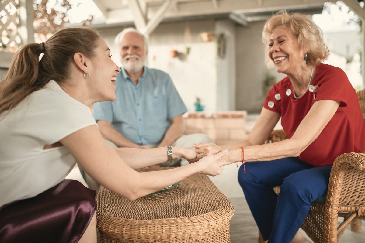 Young woman and elderly couple talking and smiling