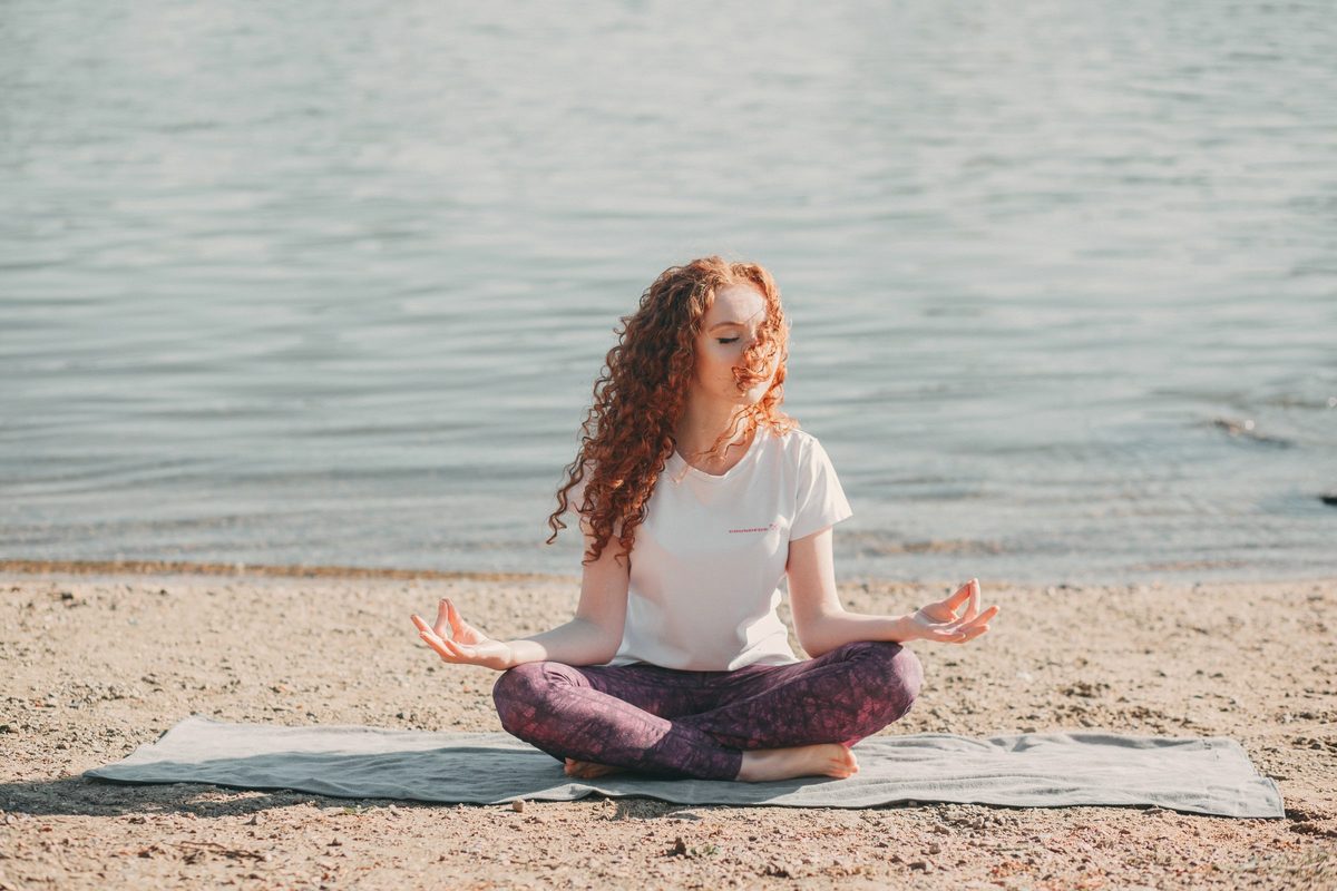 Woman doing yoga exercise at the sea shore