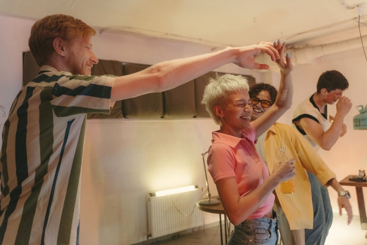 Friends dancing and laughing together at home