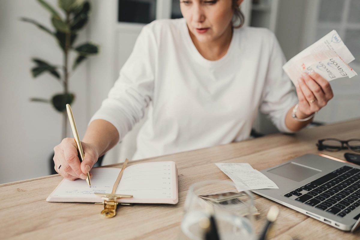Woman writing in a notepad at her desk