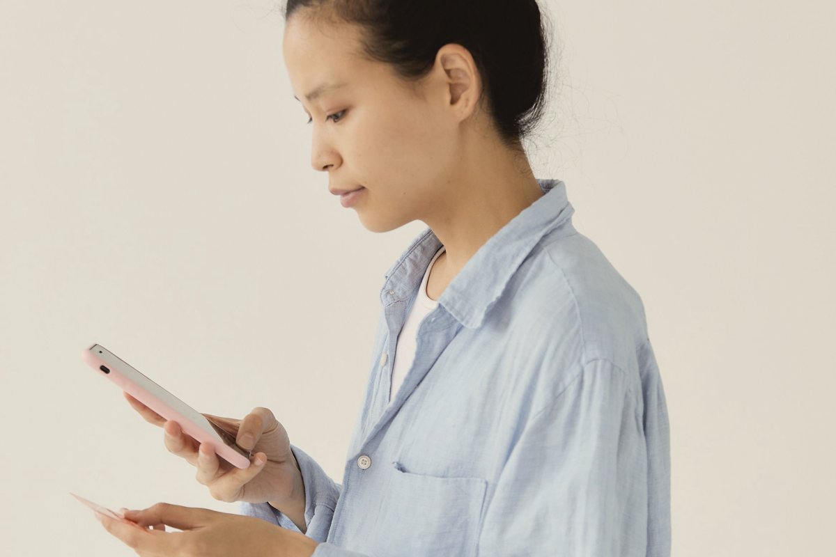 Woman using her phone to book telehealth with no referral from home