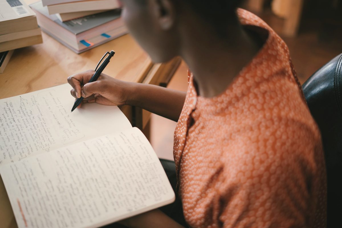 Woman writing on a notepad at a table