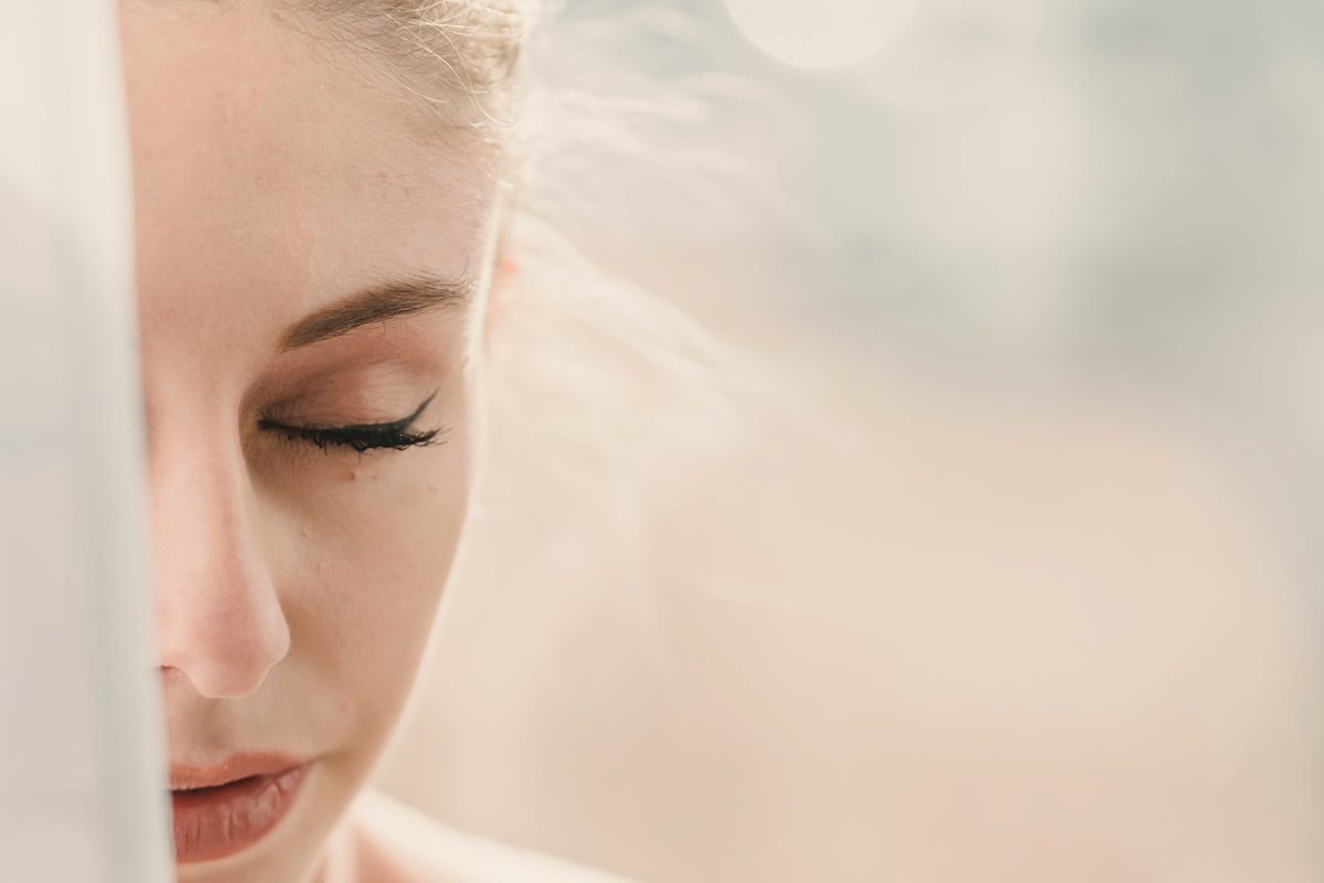 Peaceful woman meditating with closed eyes in sunny morning
