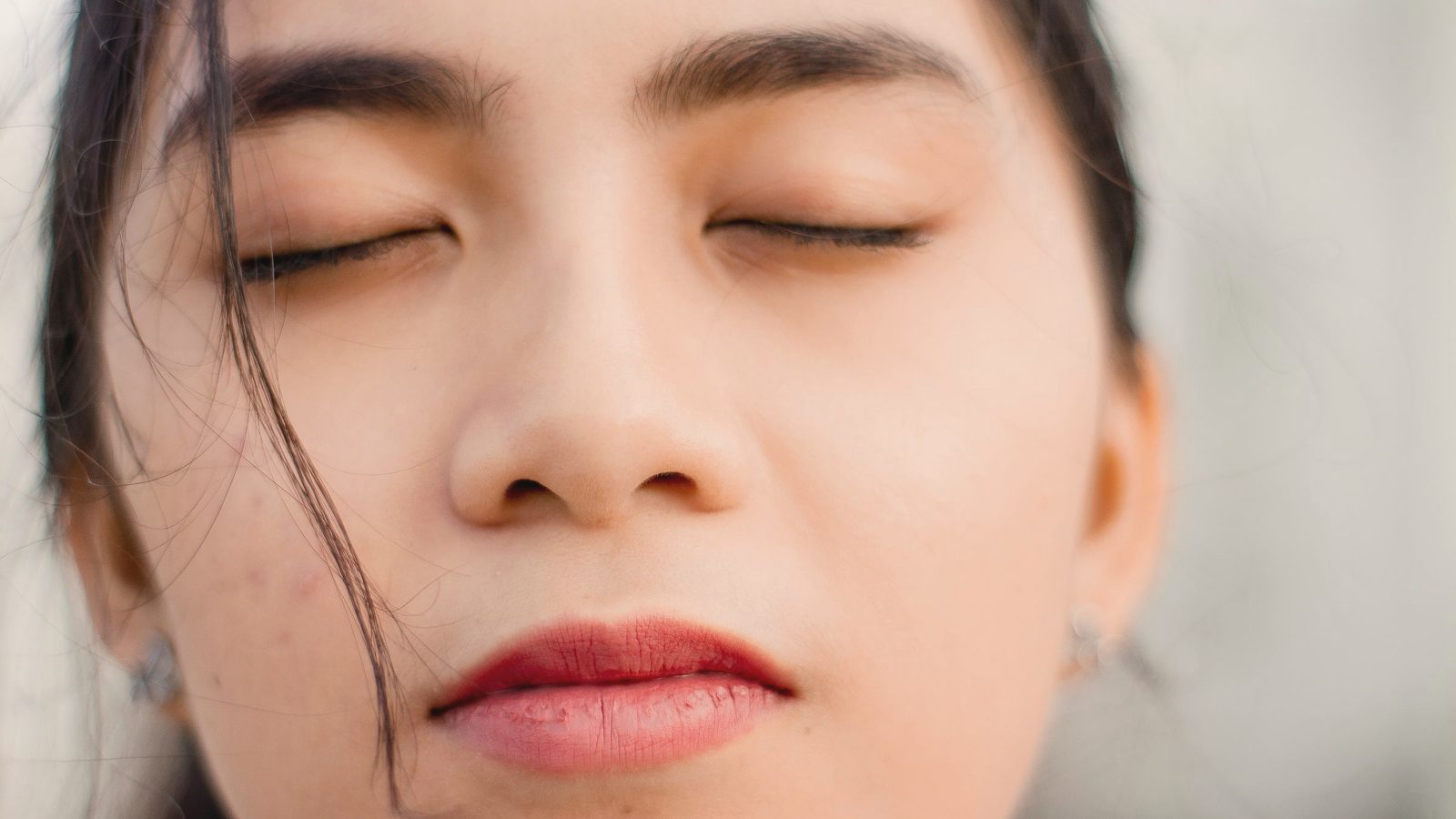 Close-up of a woman with her eyes closed in soft light