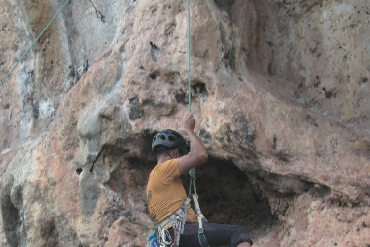 Climber gripping a rugged rock face