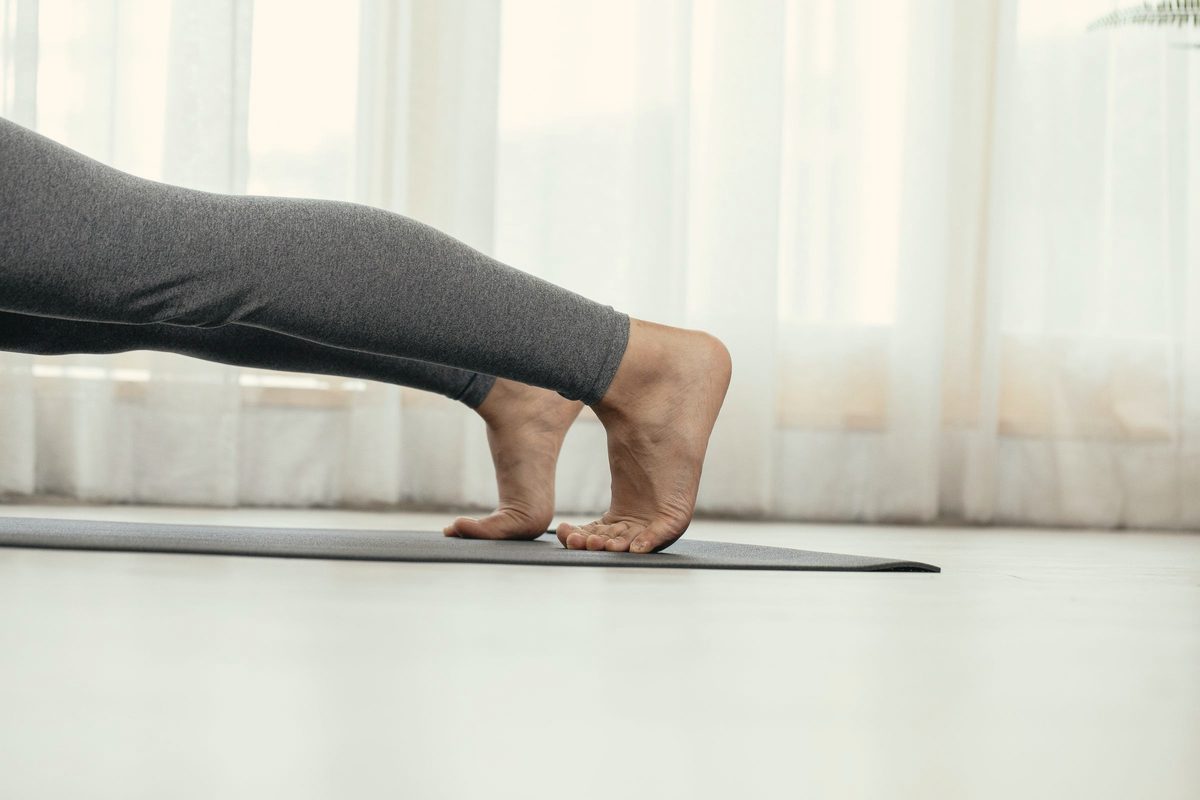 Person holding a plank on a yoga mat at home