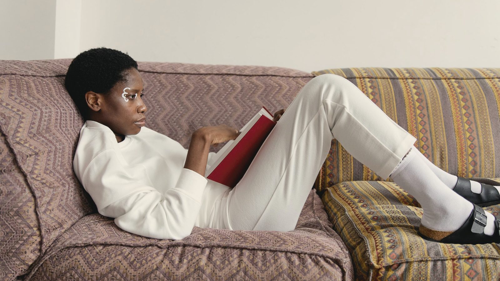 Woman lying on a sofa reading a book