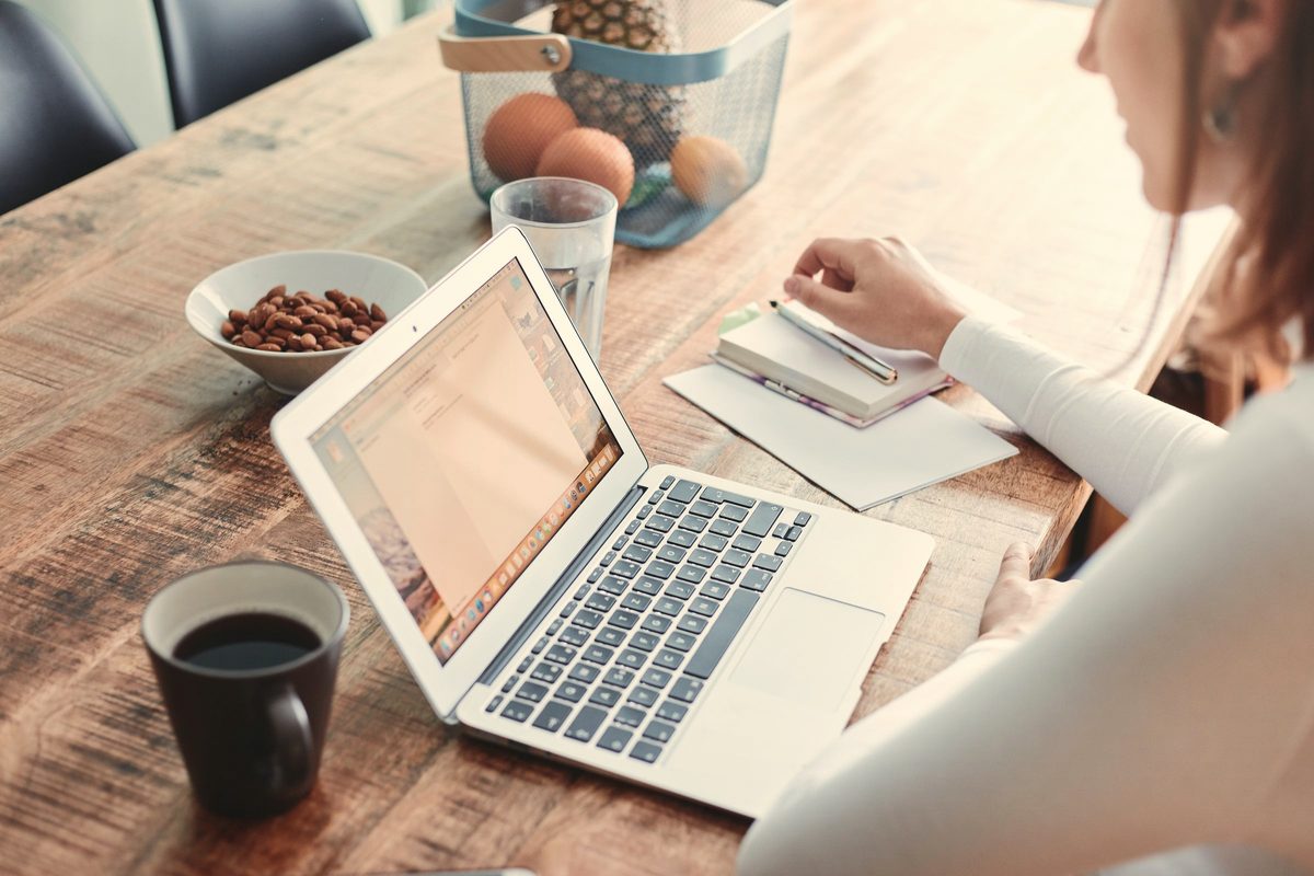 Woman reading on her laptop at the kitchen table