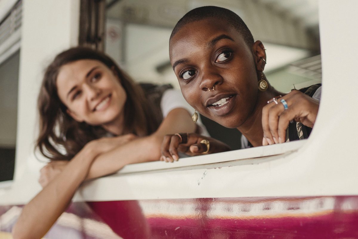 Women smiling as they look out of a train window
