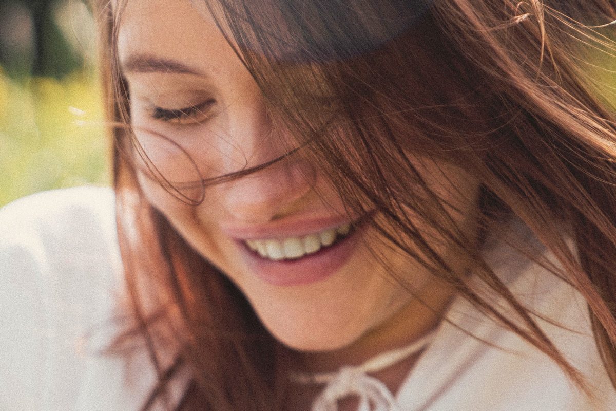 Happy woman standing outside in sunlight