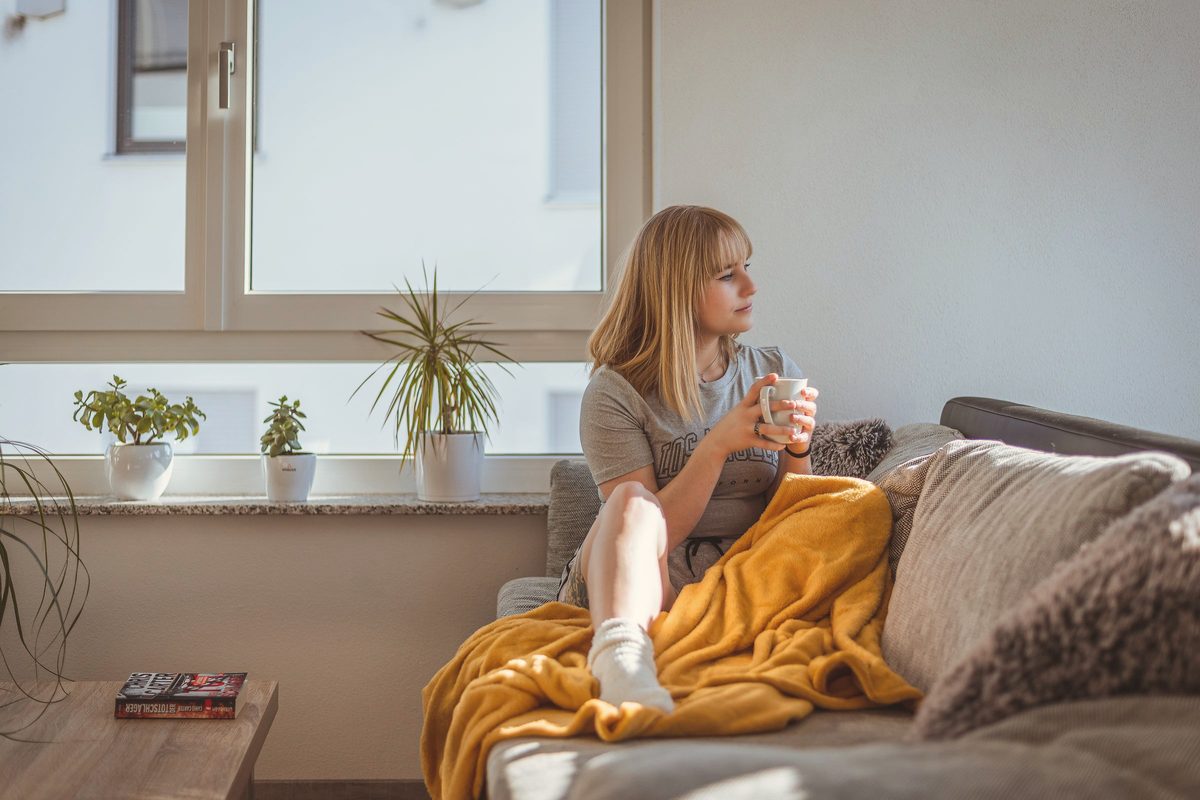 Woman unwinding on the sofa with a coffee