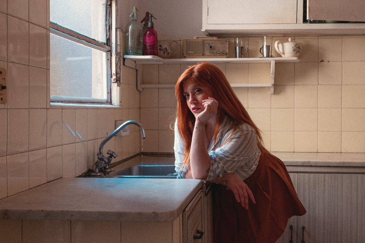Weary woman leaning on the kitchen bench