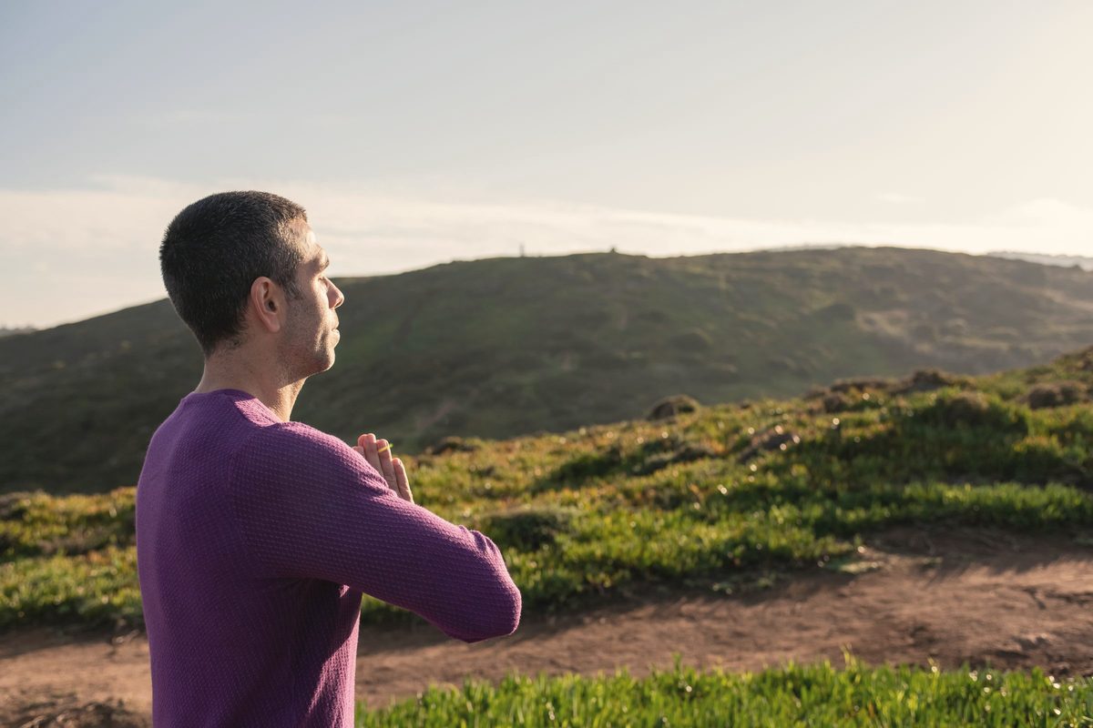 Man breathing deeply on a hillside