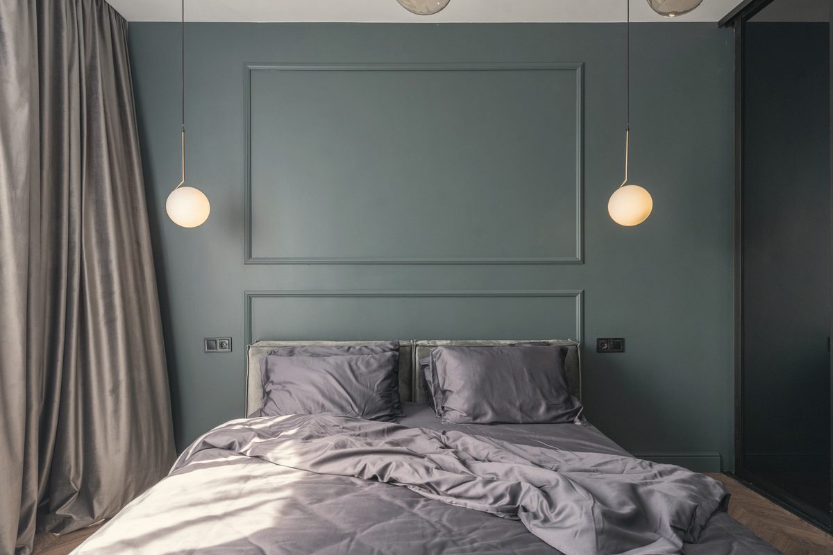 Bedroom with unmade bed near window with curtains