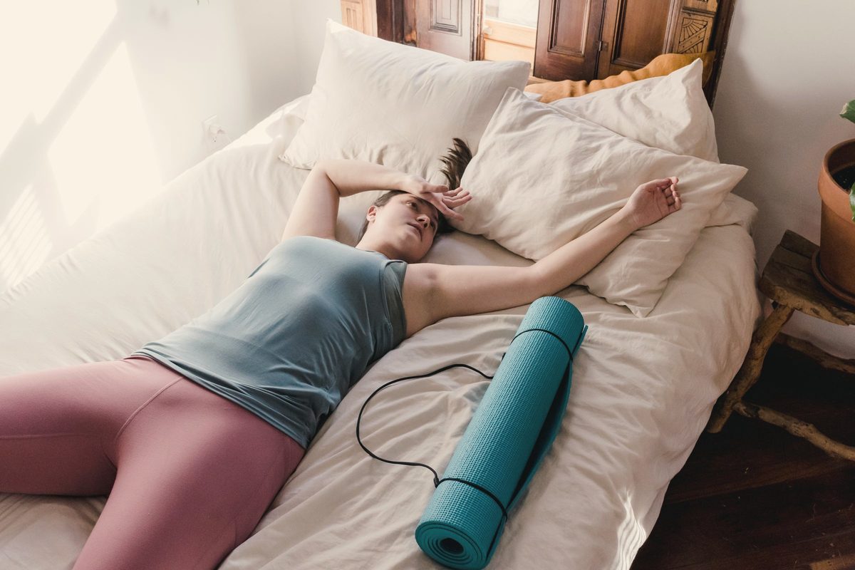 Tired woman lying back on the bed