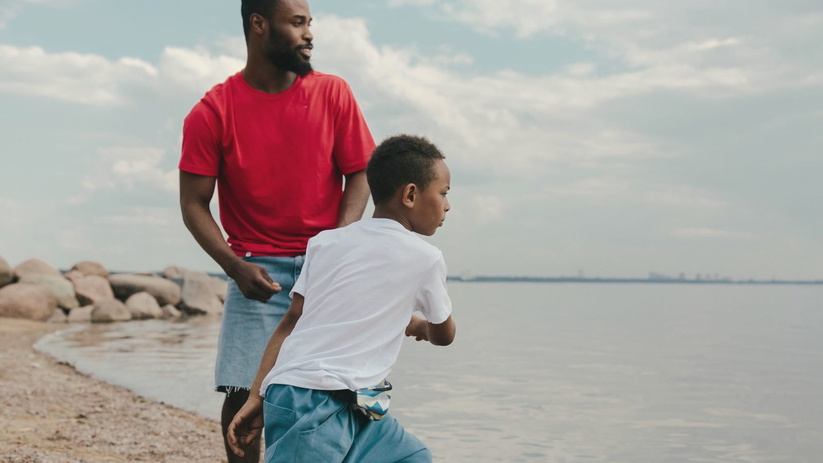 A man and a young boy standing on the beach