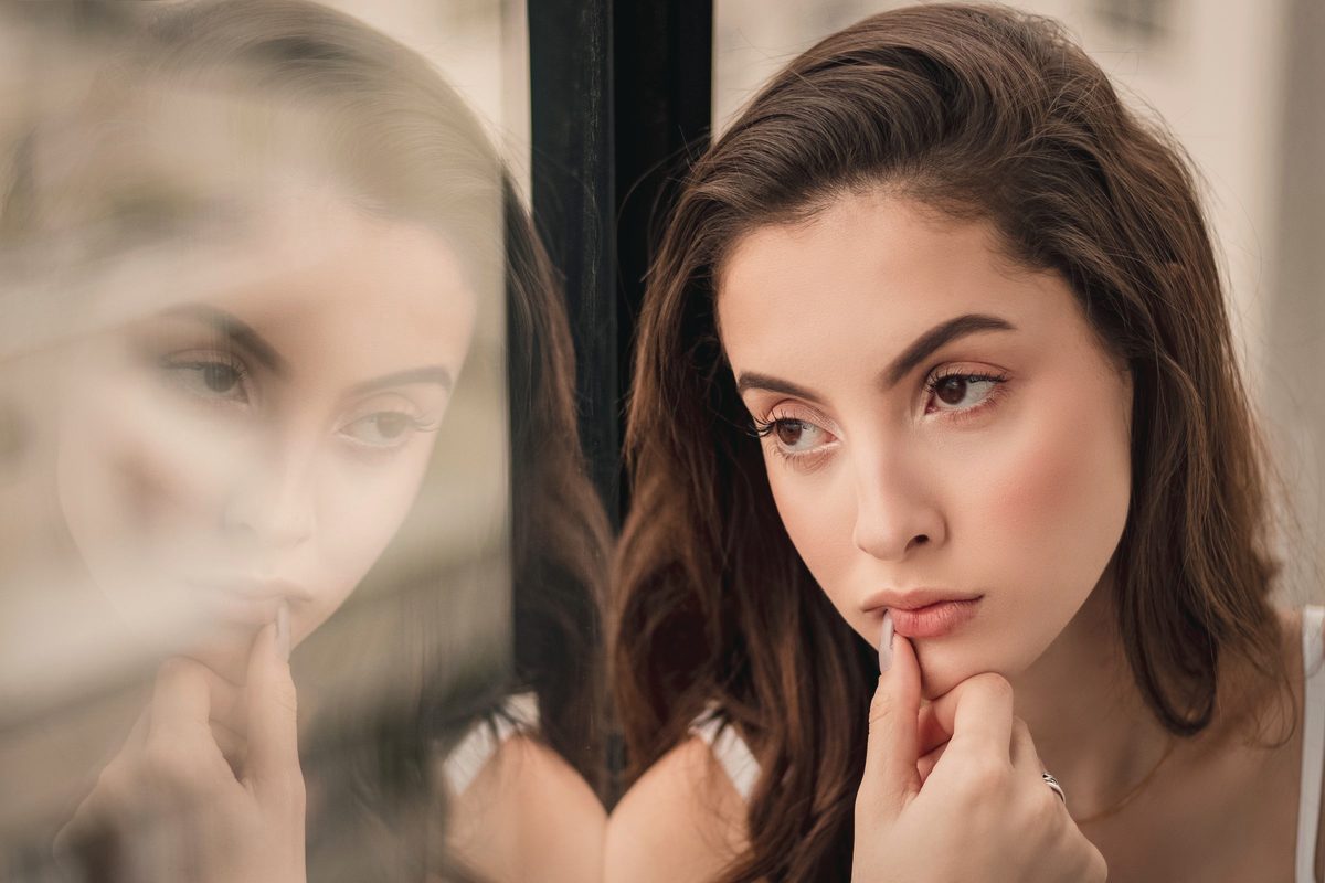 Portrait photo of woman sitting by window looking outside