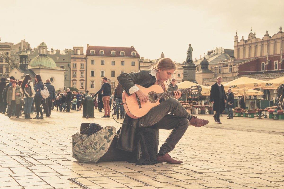 Man playing guitar in a town square
