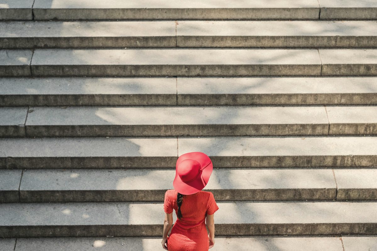 Woman in red dress climbing the stairs