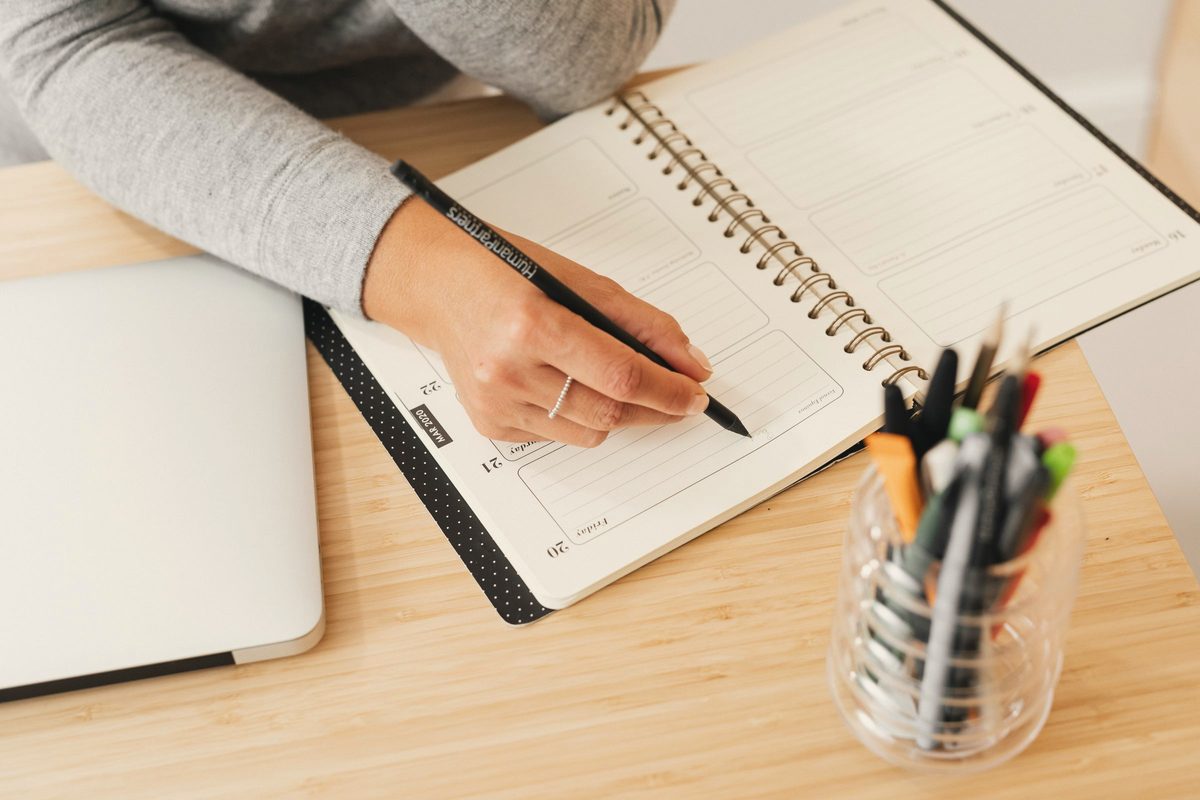 Person writing on a planner