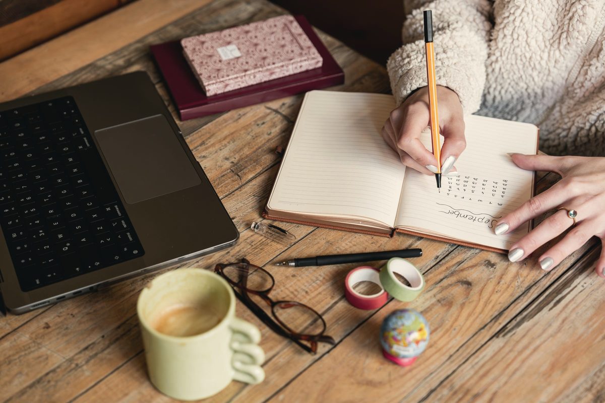 Woman writing in notebook on desk