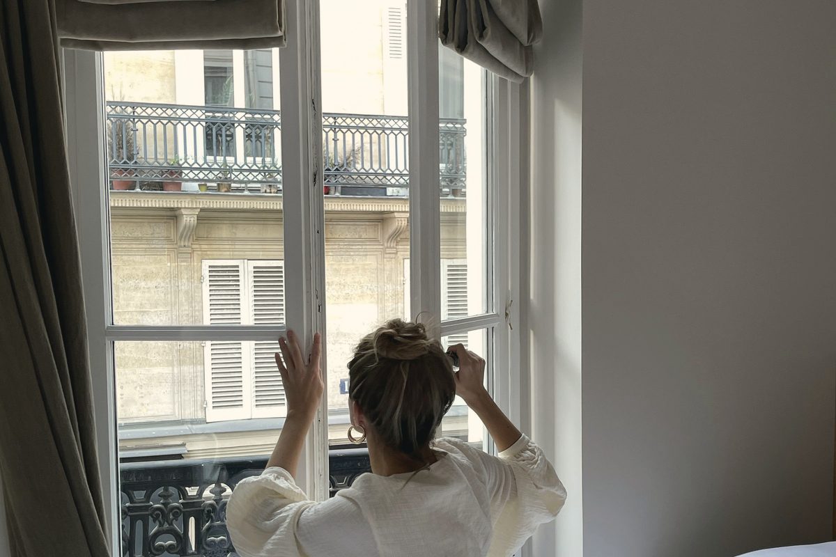 Woman opening window in bedroom
