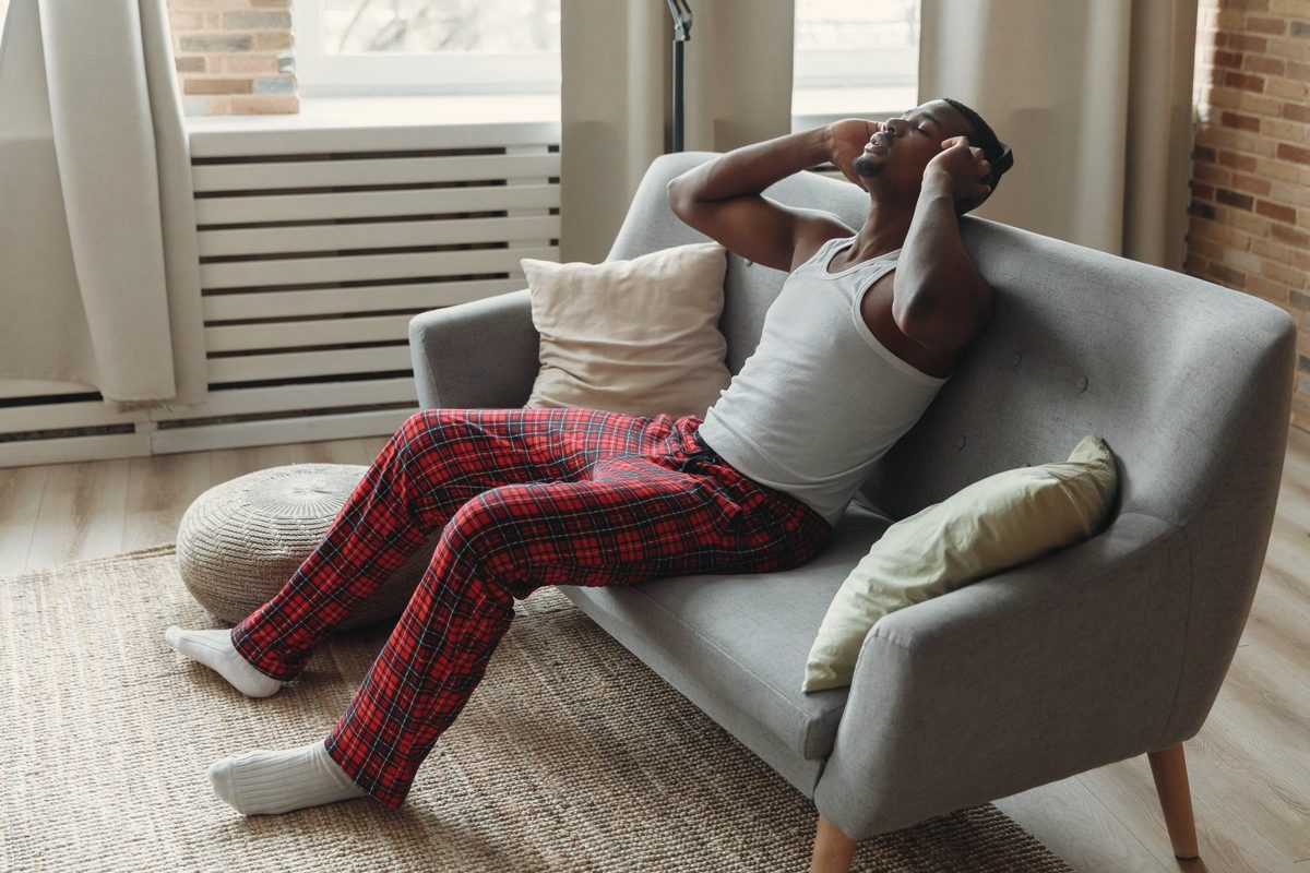 Man unwinding on the sofa with headphones