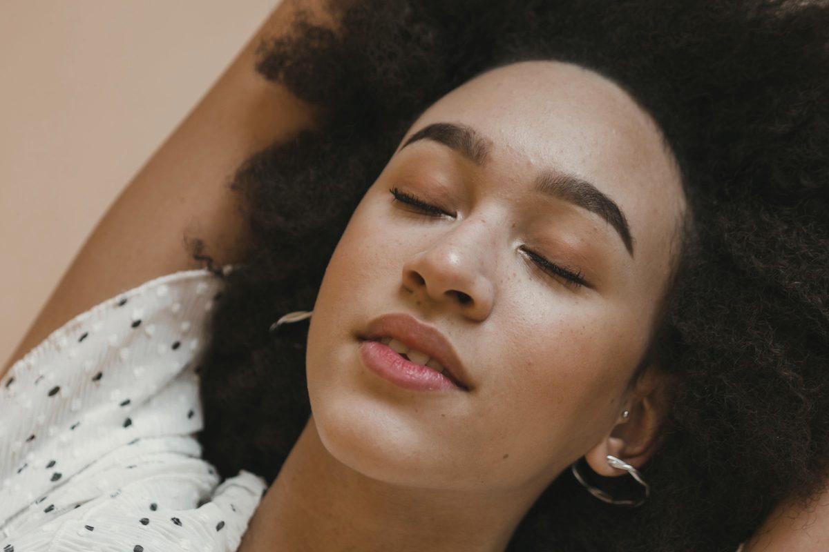 Peaceful young woman relaxing with closed eyes